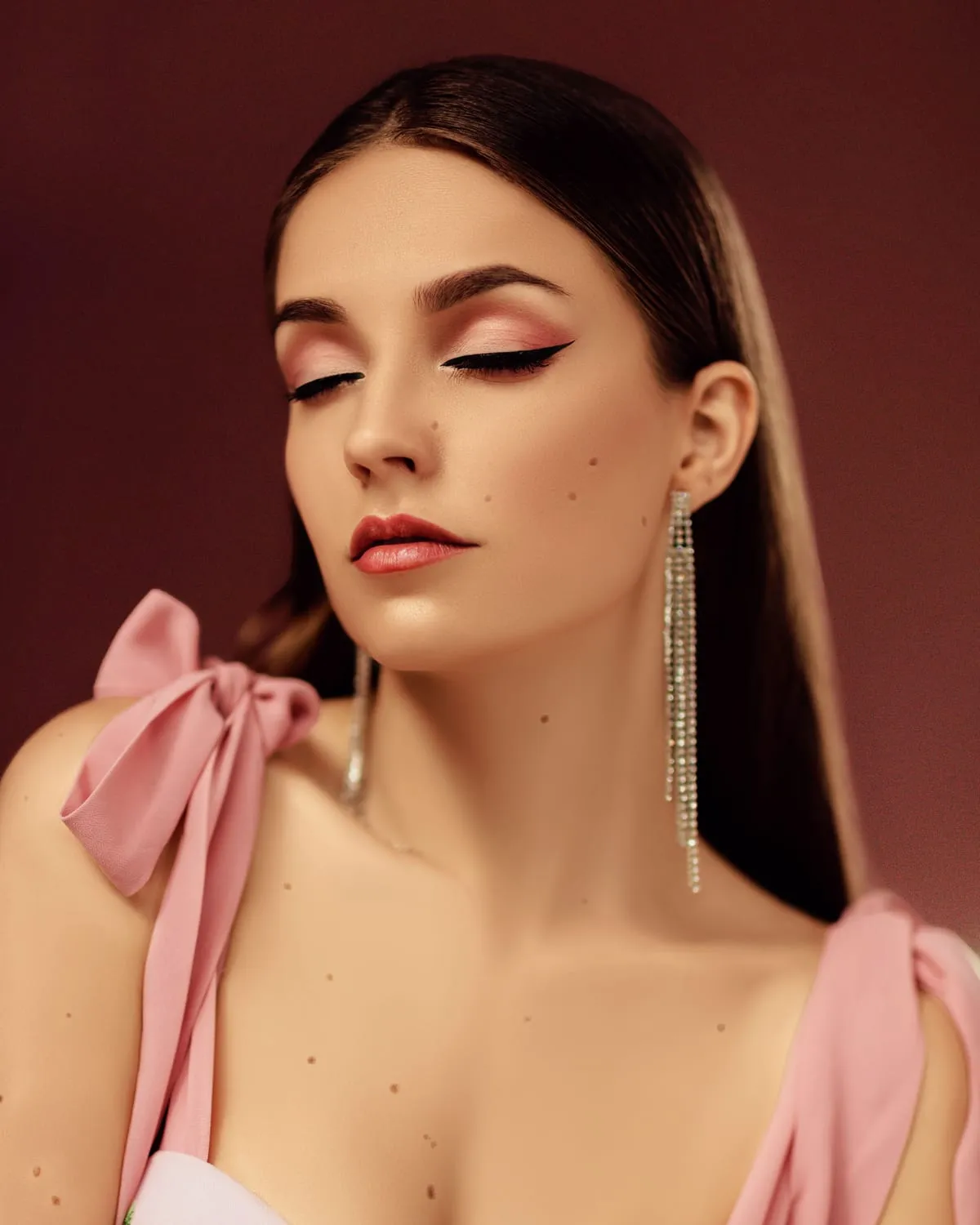 Woman wearing soft glam makeup with warm neutral eyeshadow, winged liner and a nude lip